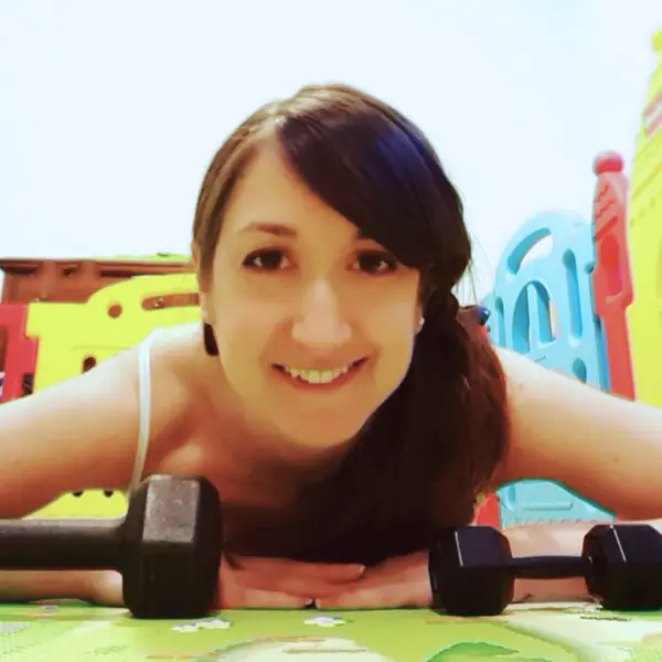 Me working out at home with a baby and toys in the background.