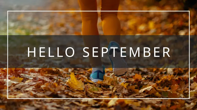 hello september - woman walking through falling leaves